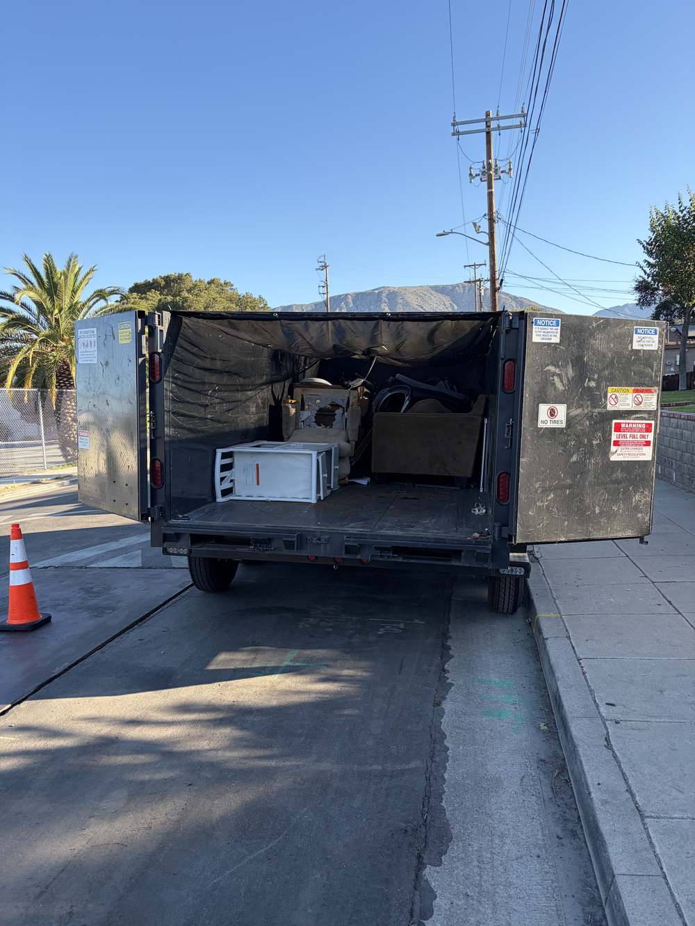 Furniture, a cabinet, and other items loaded for removal in Northridge